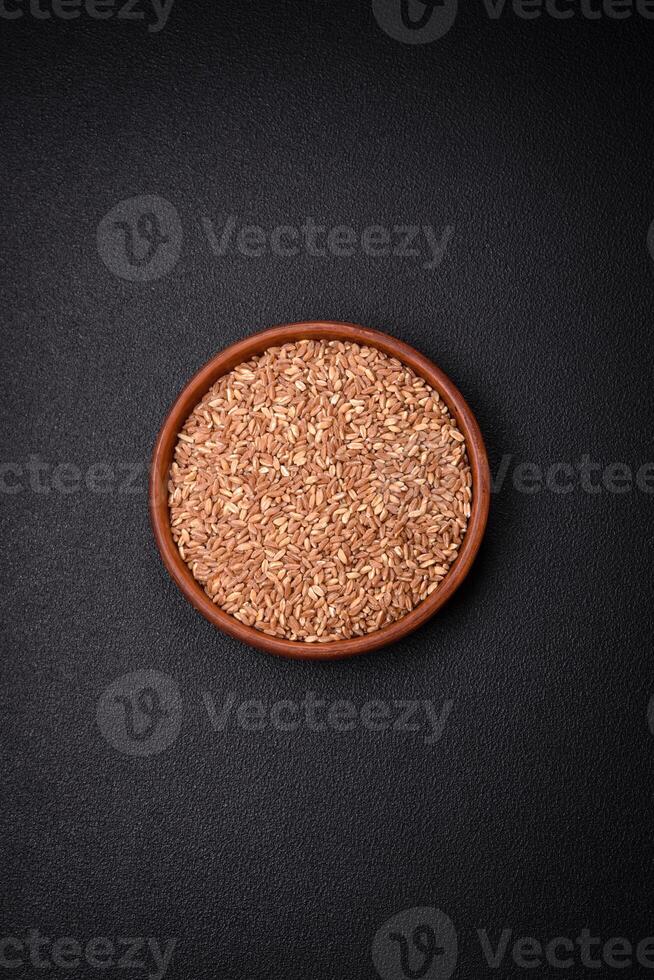 Large grains of wheat porridge are brown in color when raw photo