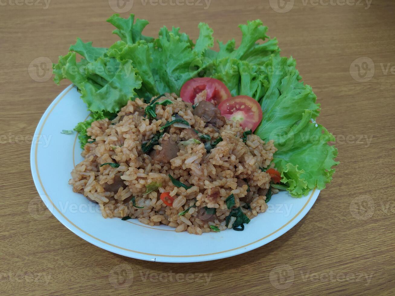 delicioso indonesio frito arroz nasi goreng con un montón de lechuga, mostaza verduras y Tomates servido en un blanco plato foto