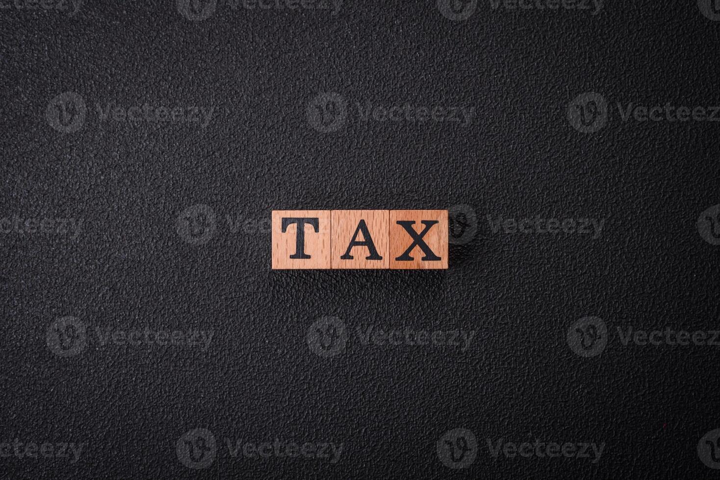 The inscription Tax made of wooden cubes on a plain background photo
