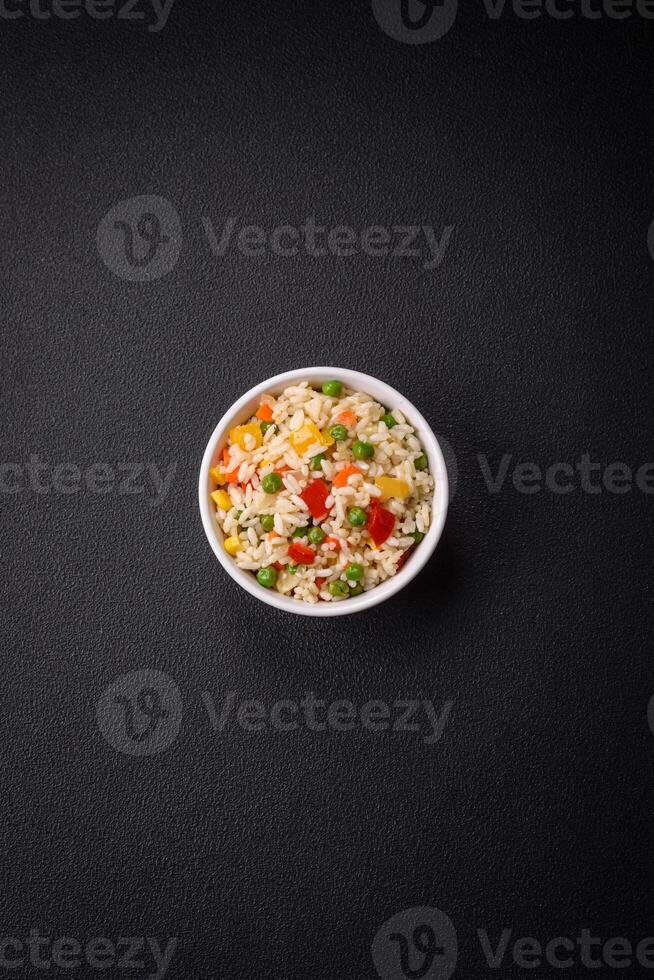 Delicious white boiled rice with vegetables, sweet peppers, carrots, peas photo