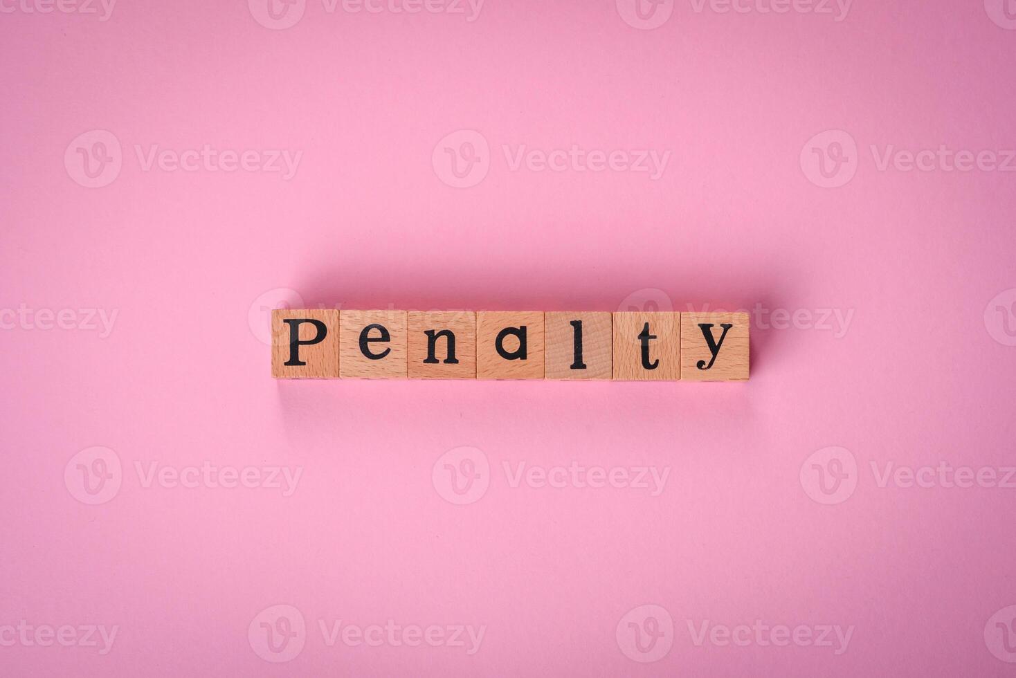 The inscription Penalty made up of wooden cubes on a plain background photo