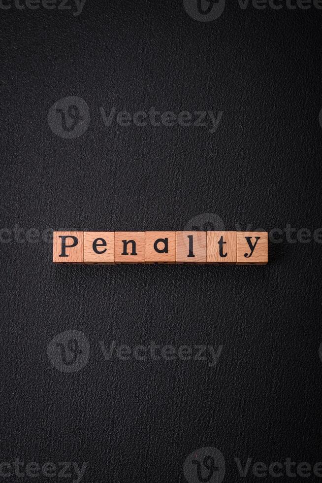 The inscription Penalty made up of wooden cubes on a plain background photo