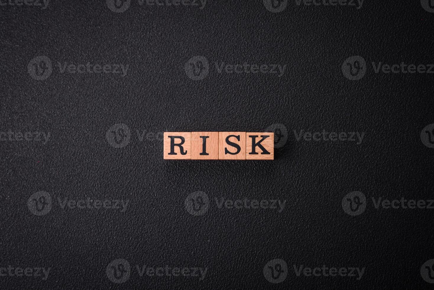 The inscription Risk made of wooden cubes on a plain background photo