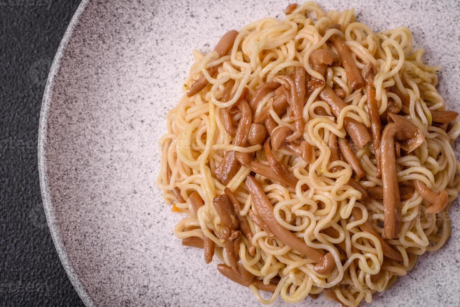 Delicious Asian cuisine dish with rice noodles, peppers, mushrooms and spices photo