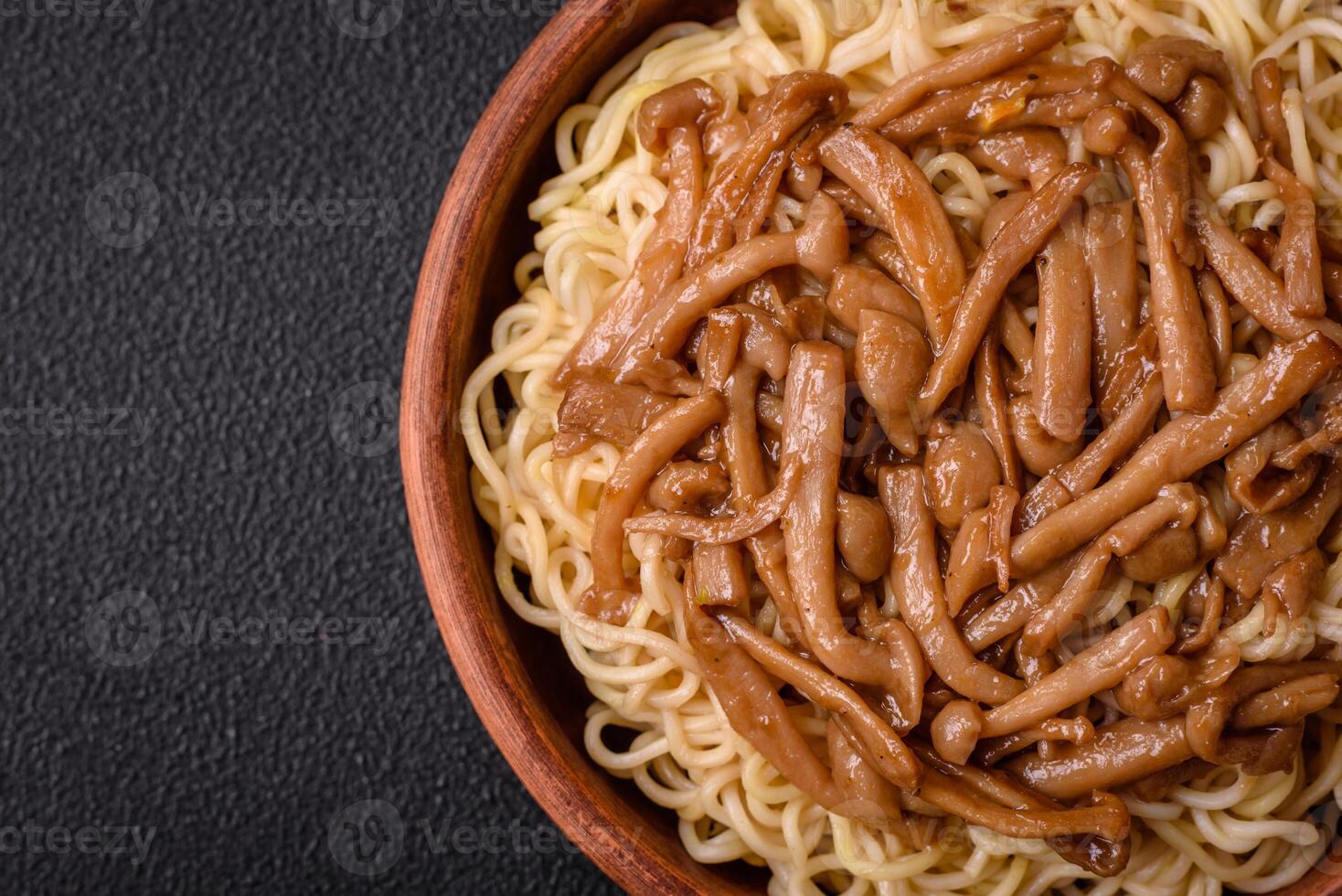 Delicious Asian cuisine dish with rice noodles, peppers, mushrooms and spices photo