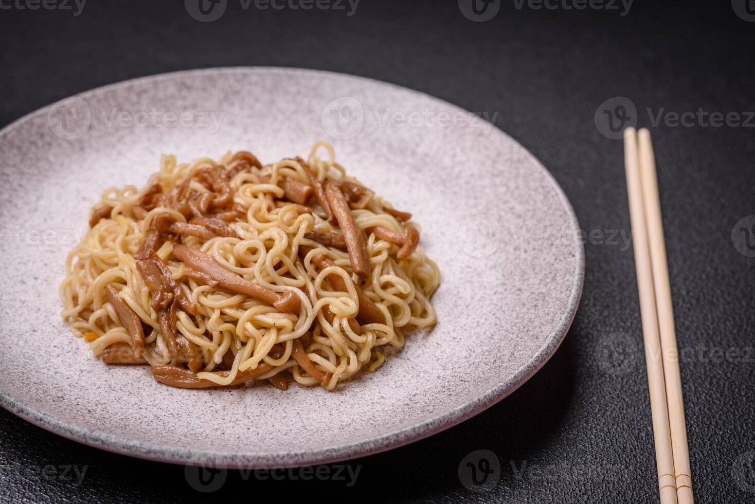 Delicious Asian cuisine dish with rice noodles, peppers, mushrooms and spices photo