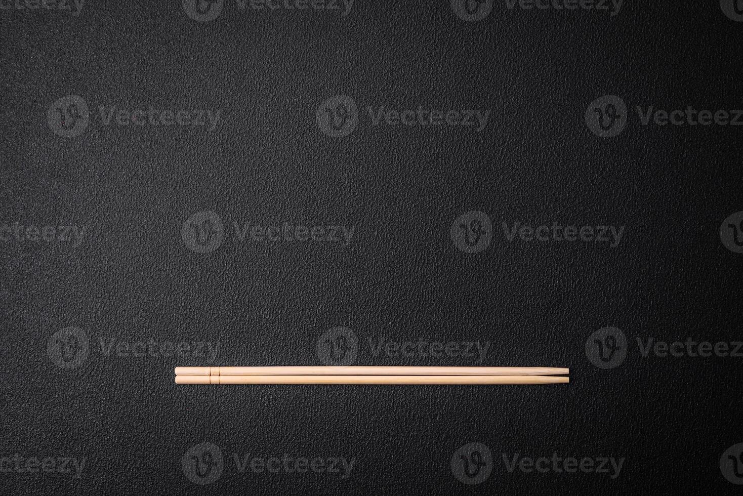 Light wooden chopsticks on a blank background as a backdrop for an Asian dish photo