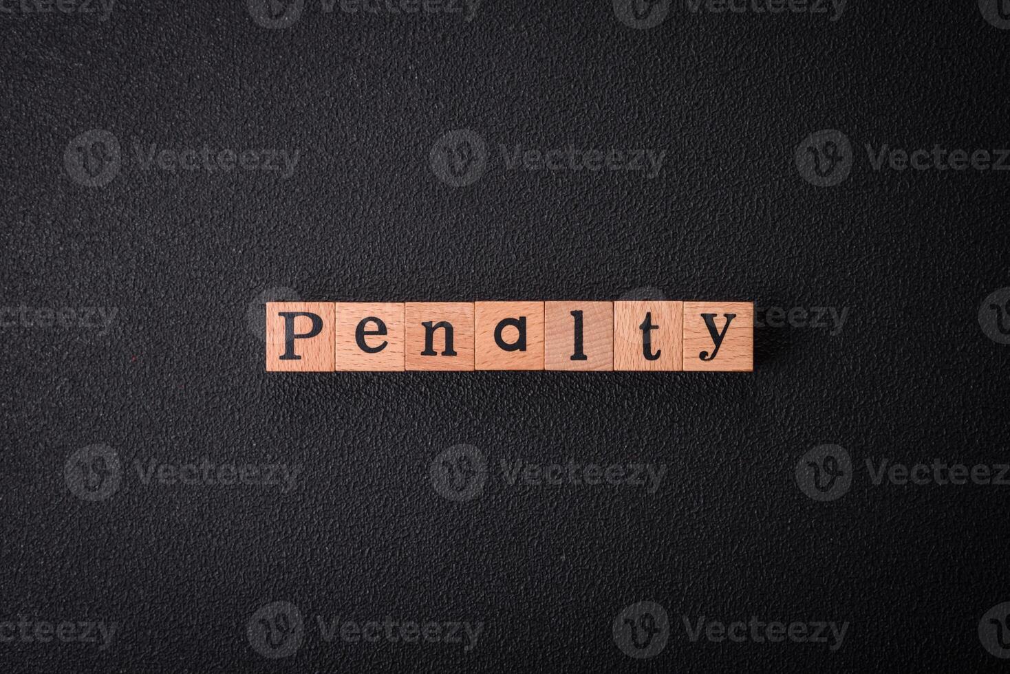 The inscription Penalty made up of wooden cubes on a plain background photo