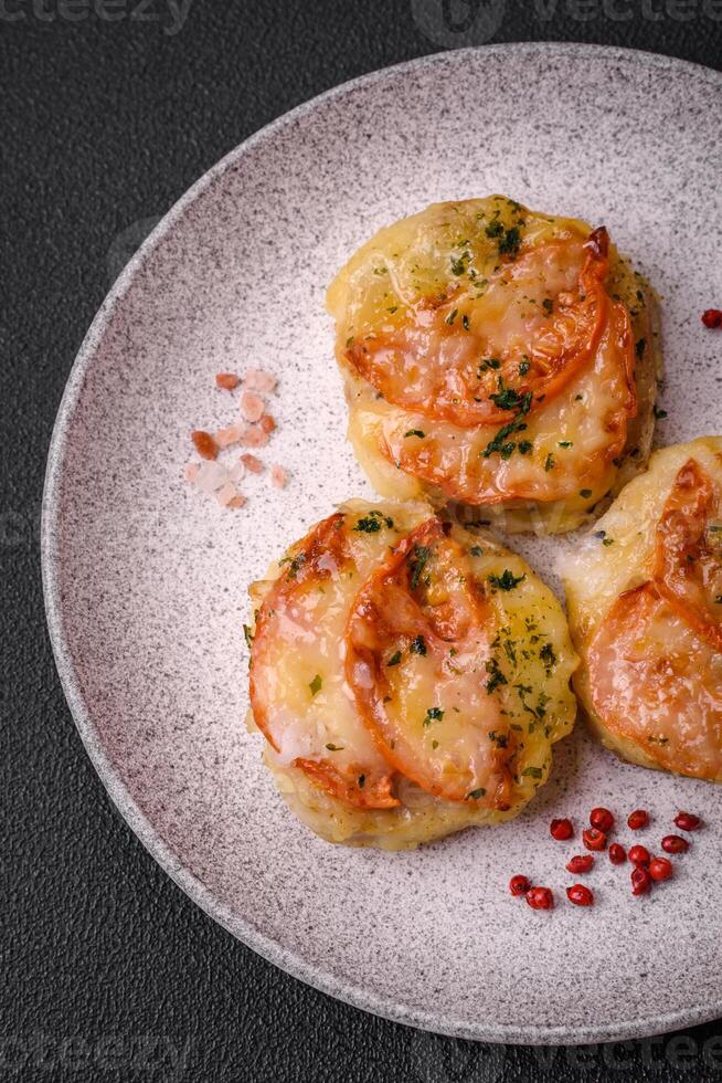 Delicious baked fish fillet with cheese, tomatoes, salt, spices and herbs photo