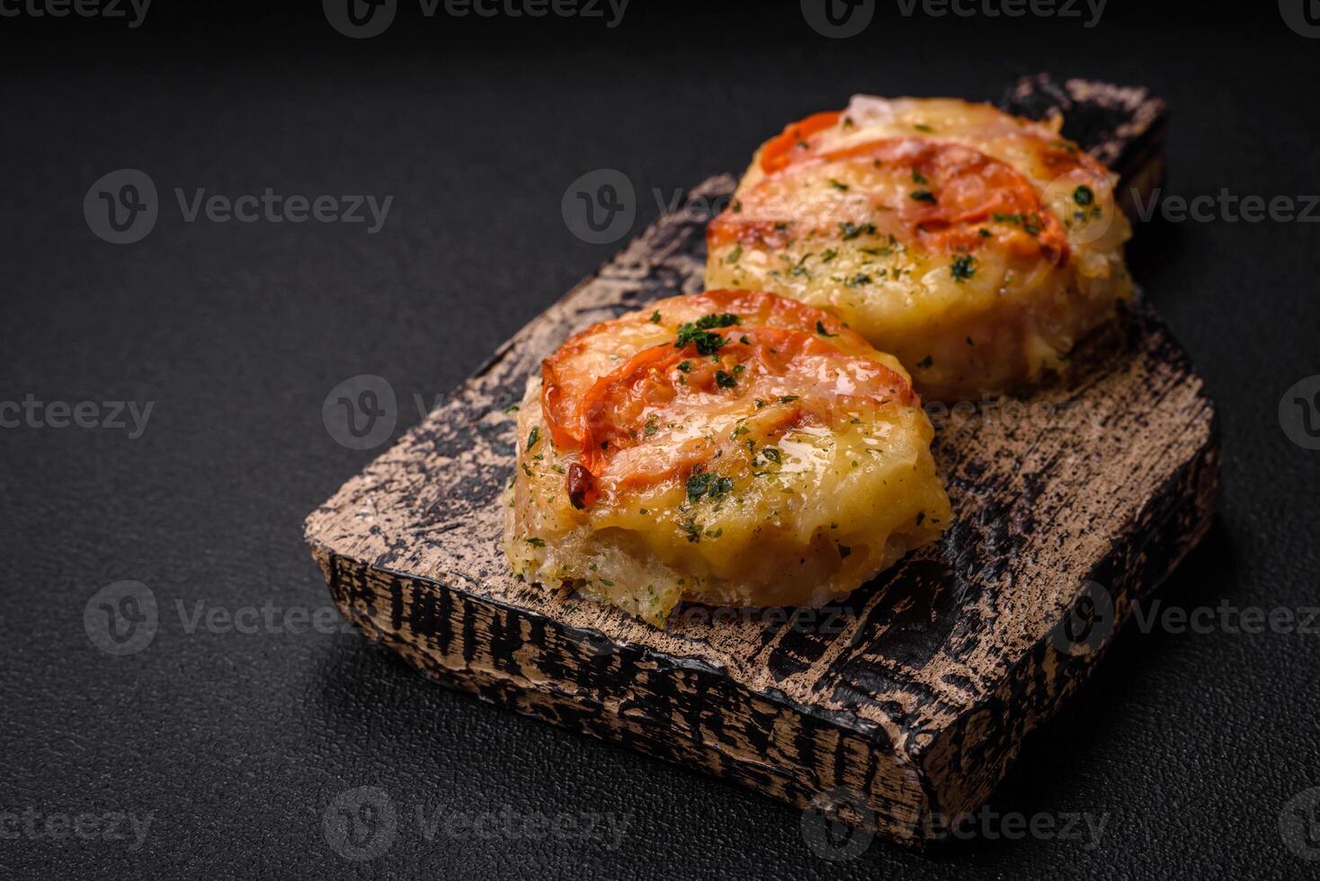 Delicious baked fish fillet with cheese, tomatoes, salt, spices and herbs photo