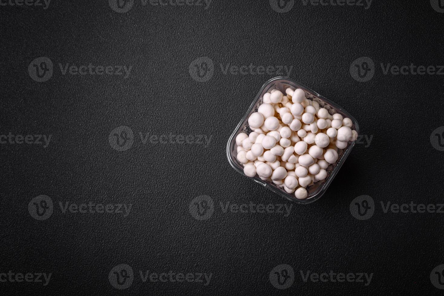 Small white edible beech mushrooms with salt and spices on a plain background photo