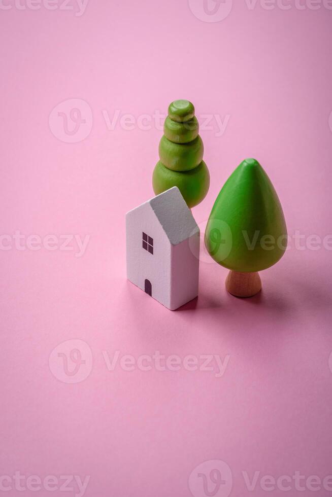 A small wooden house and keys as an idea for investing in your own home and achieving the goal of buying real estate photo