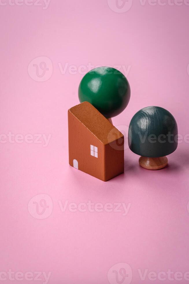 A small wooden house and keys as an idea for investing in your own home and achieving the goal of buying real estate photo