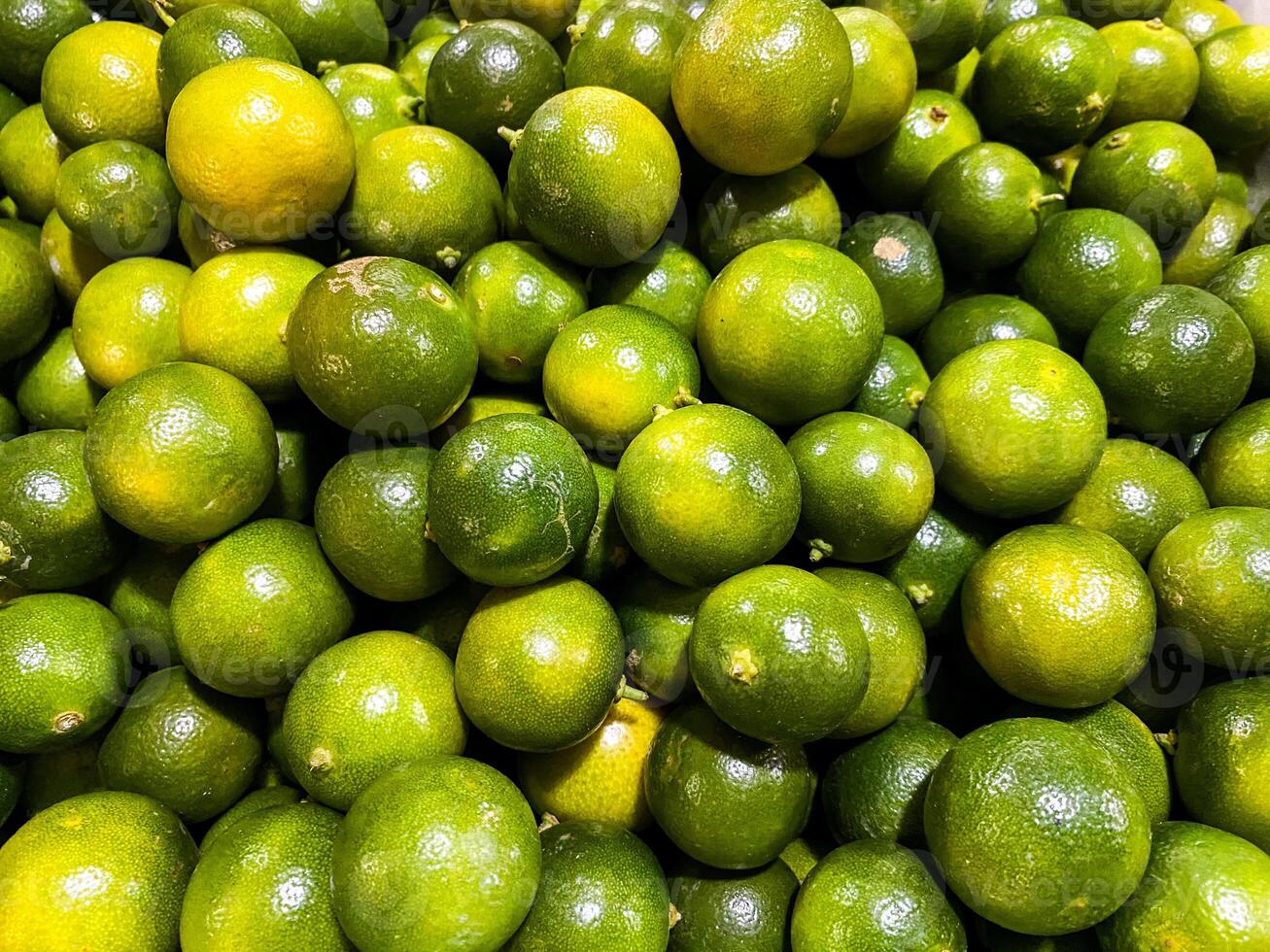 Top view of fresh green lemons as a background. photo