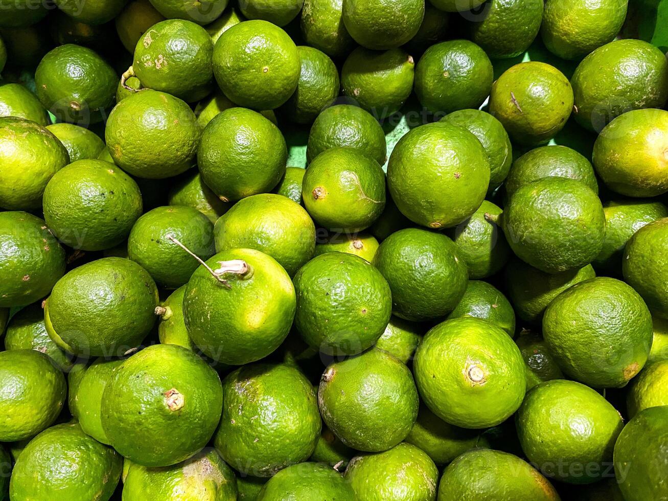 Top view of fresh green lemons as a background. photo