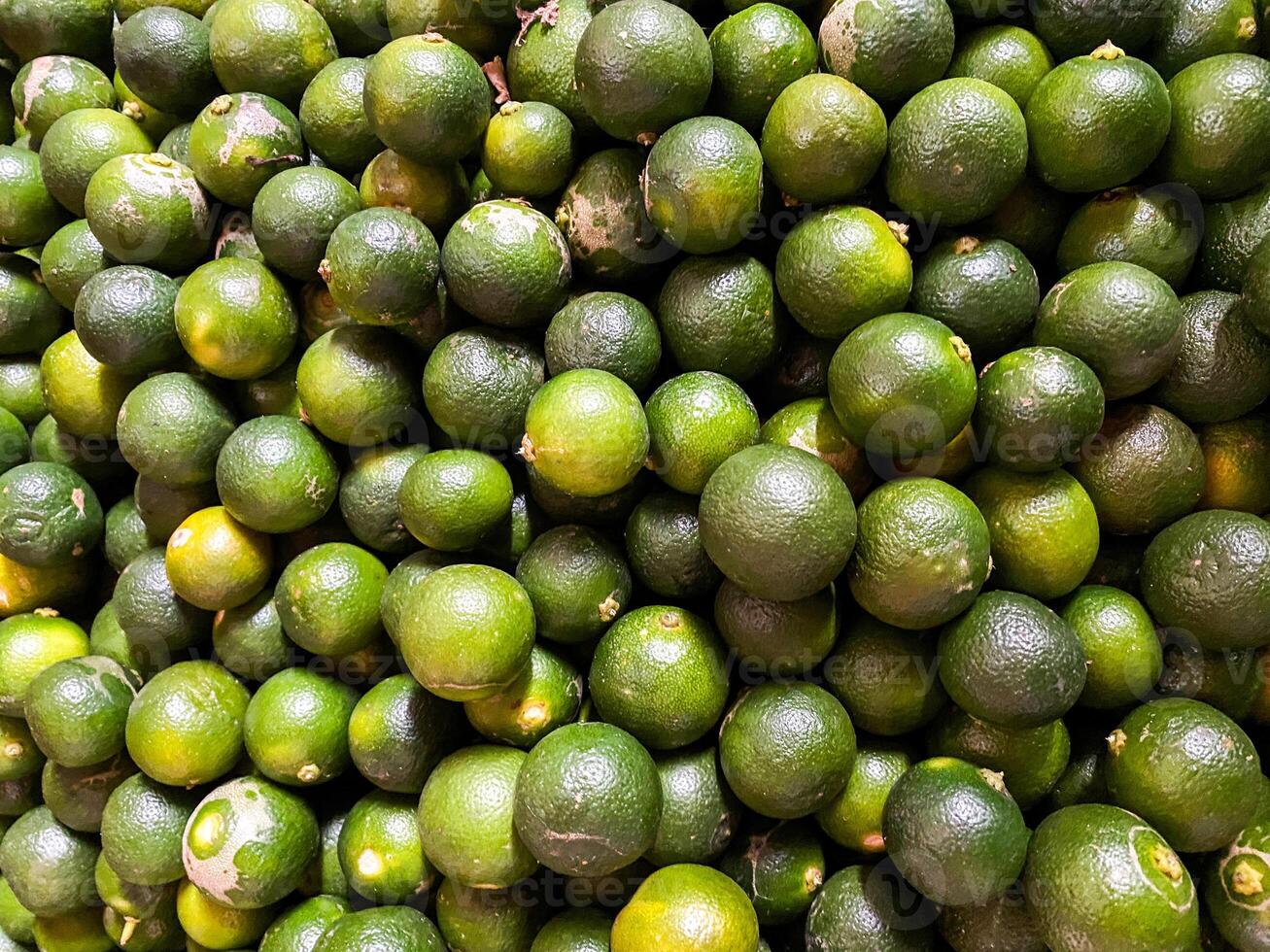 Top view of fresh green lemons as a background. photo