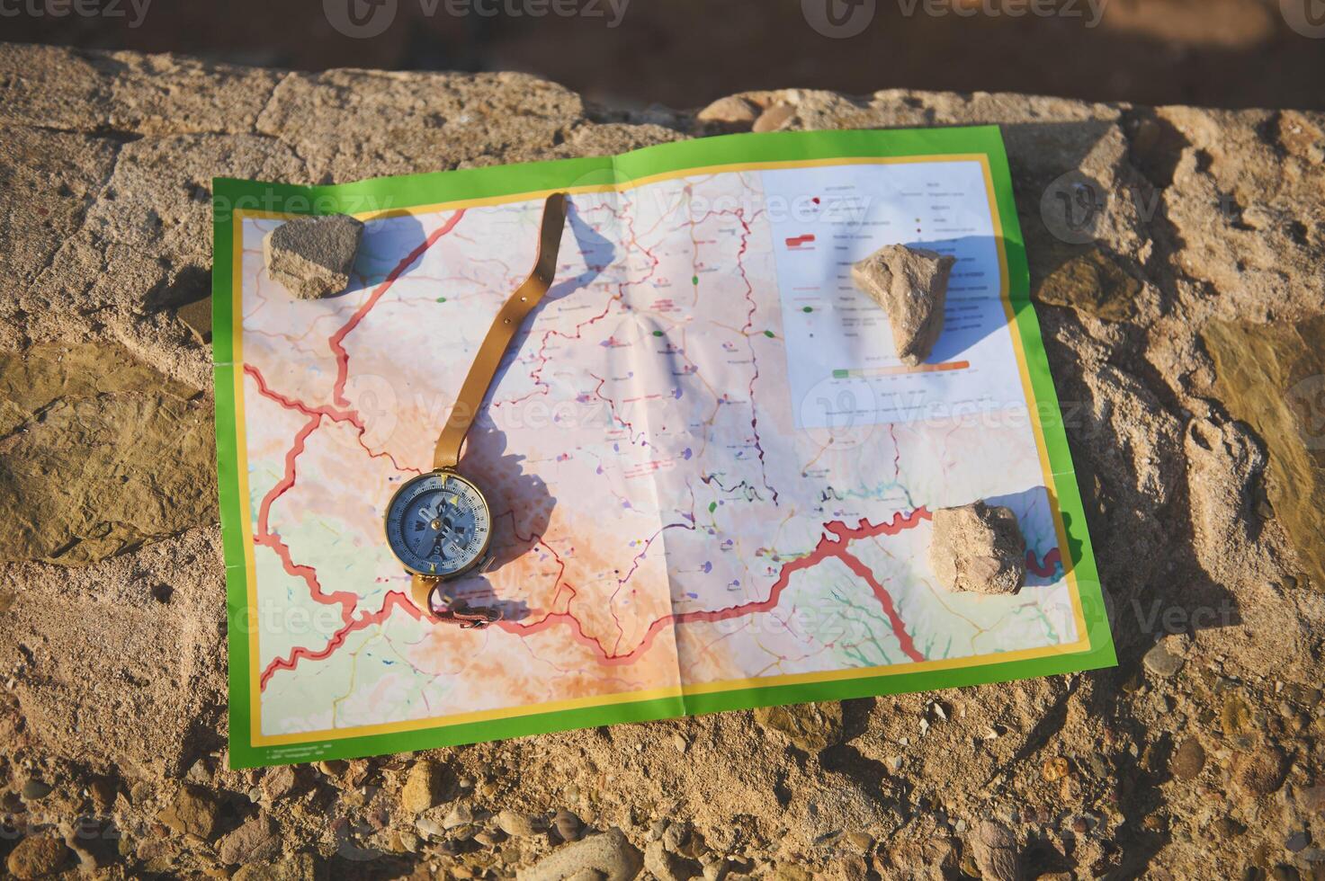 Still life. View from above compass lies on a map on a cliff, a magnetic arrow points north, navigation in the seacoast photo