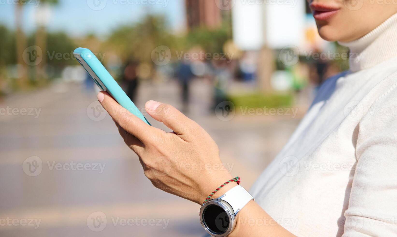 Woman's hand with smart wrist watch, checking new mobile app on smart phone, browsing web site, online communication photo