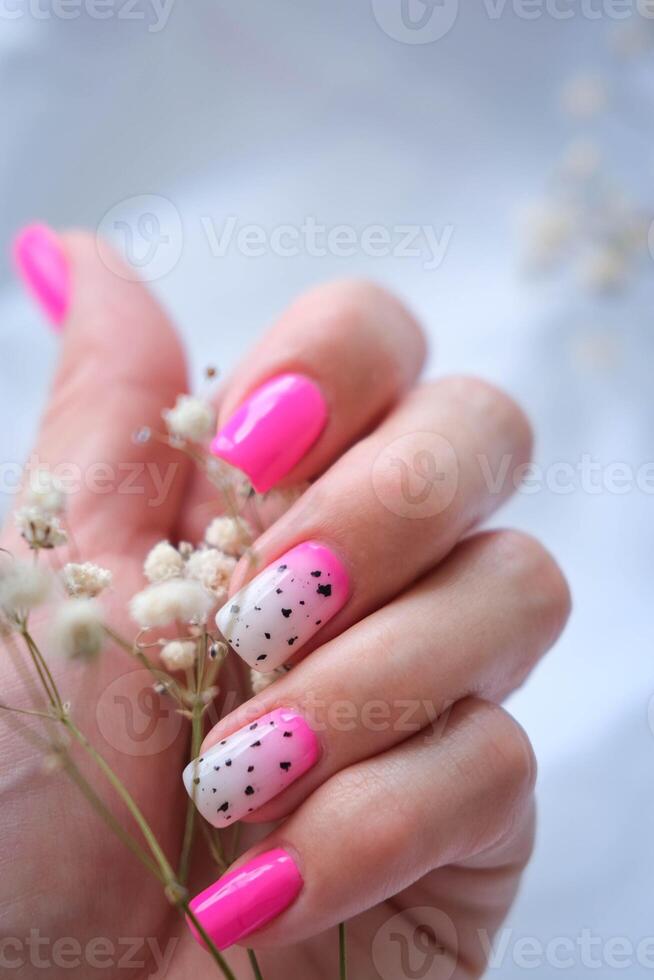 Women's hands with a fashionable pink manicure hold dried flowers in their hands. Spring - summer nail design photo