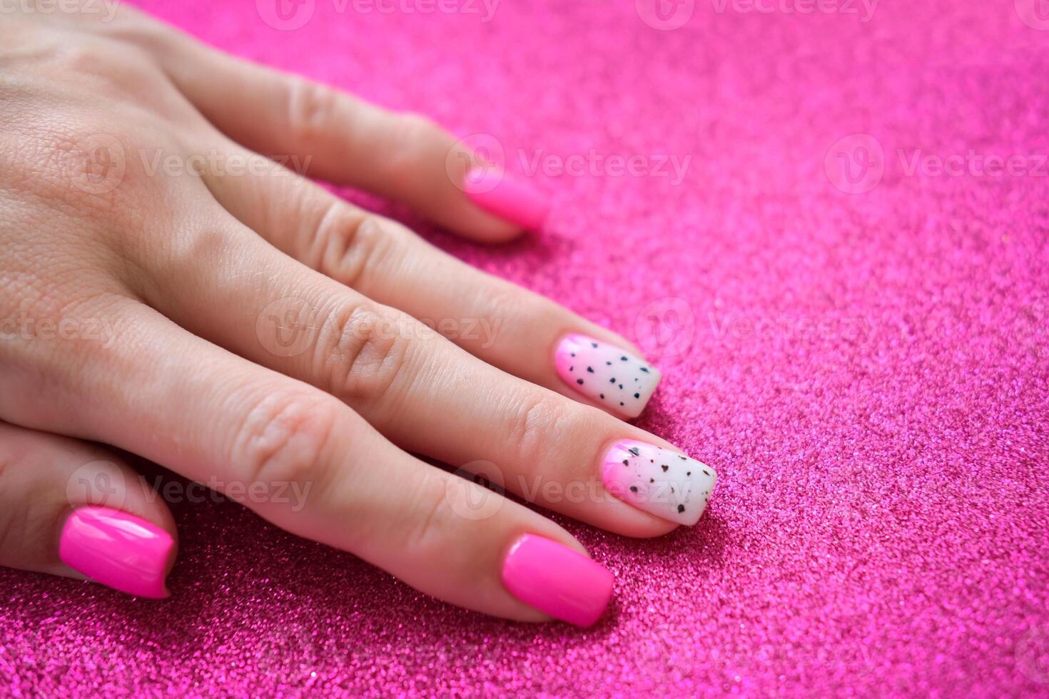 Beautiful female hands with manicure on a pink shiny background. Tinted nail design. Summer manicure. Copy space. photo