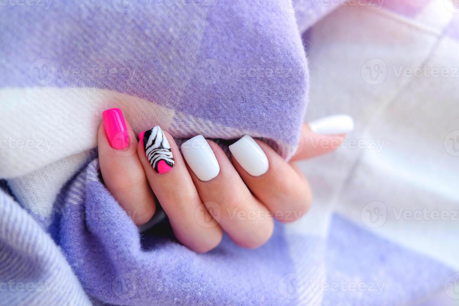 Beautiful female hands with manicure on a purple background. Tinted nail design. Summer pink manicure. Copy space. photo