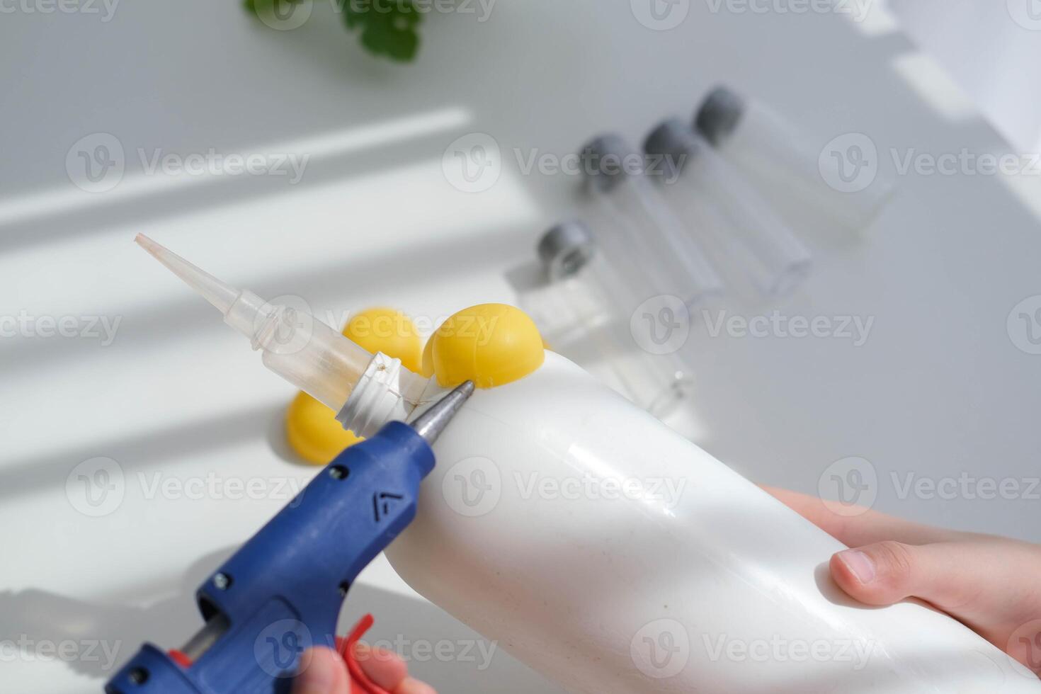 Step-by-step instructions for making crafts from improvised materials. Handmade at school craft rocket for the day of cosmonautics. The child is gluing parts to a plastic bottle. Step 7 photo