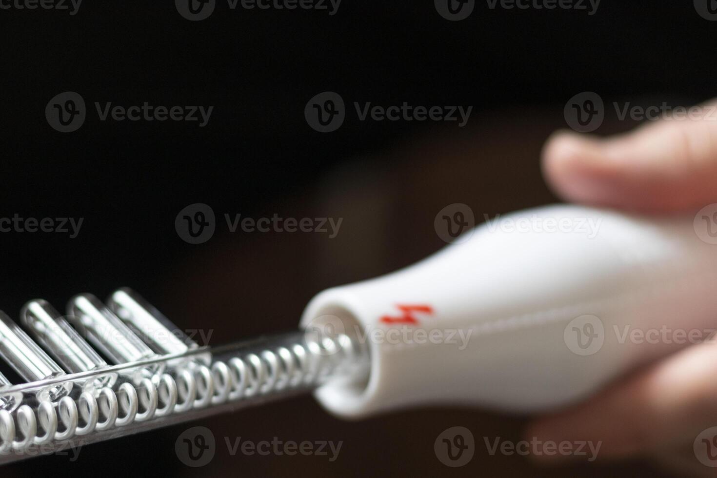 Close up shot of the high frequency comb tool for hair and scalp treatment. Healthcare photo