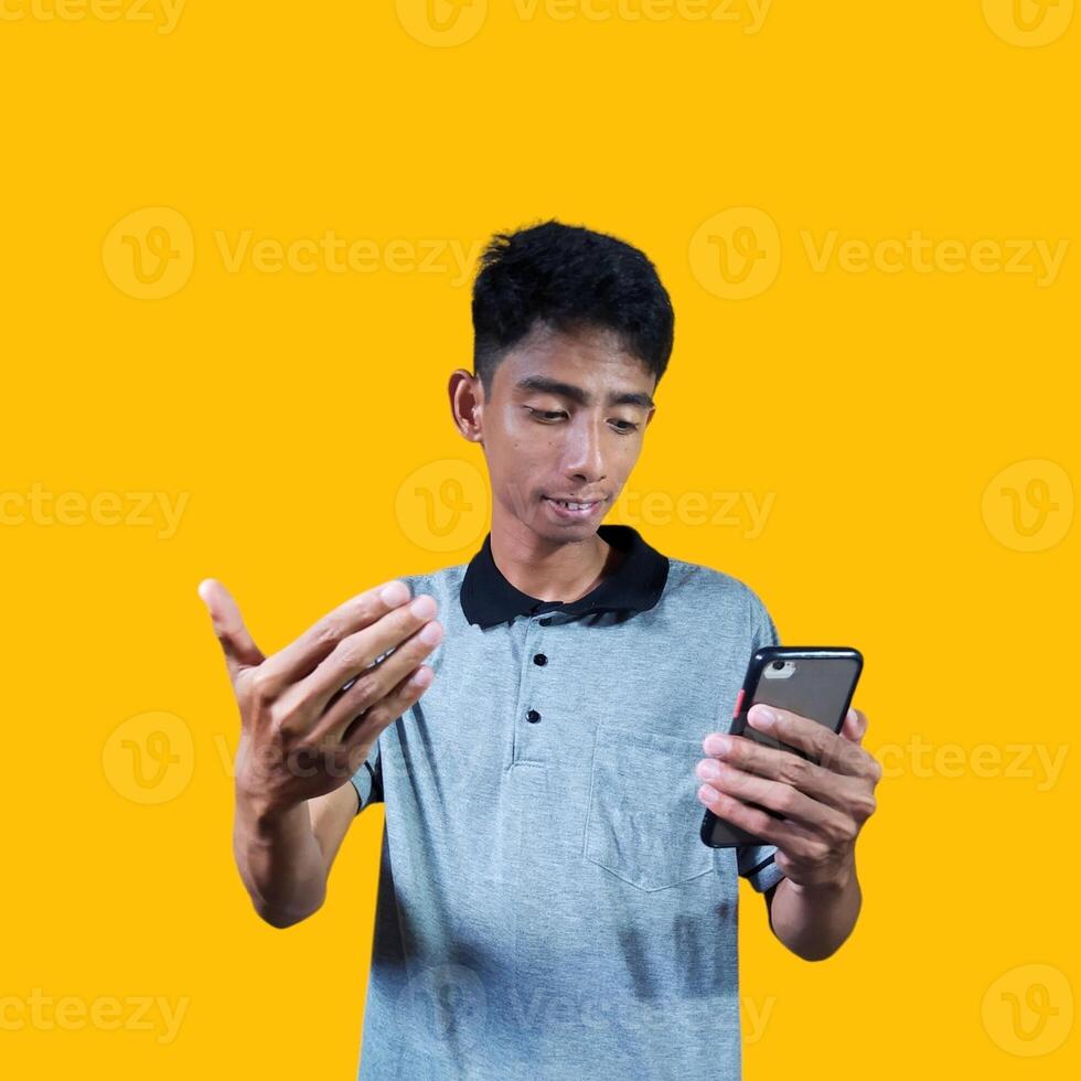 Young Asian man isolated on yellow background inviting come with hands, glad you came photo