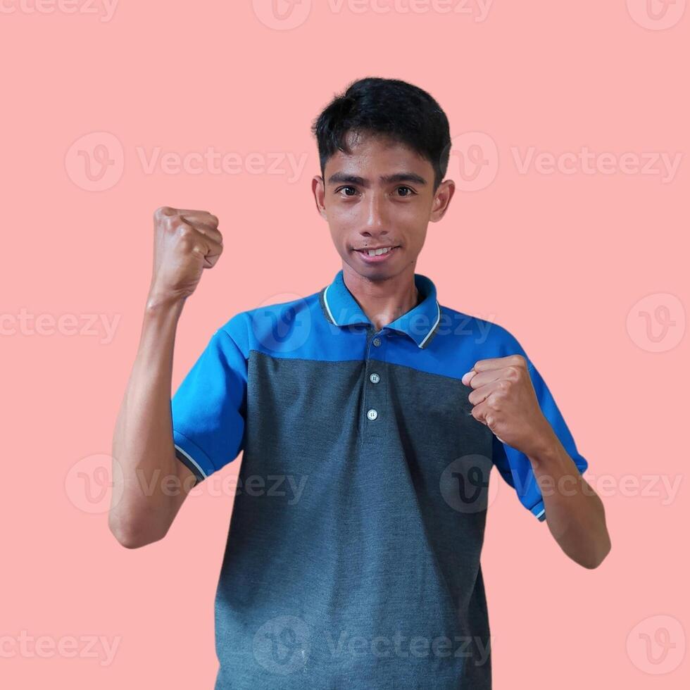 emocionado asiático hombre vistiendo azul camiseta señalando a parte superior Copiar espacio, aislado rosado antecedentes. foto