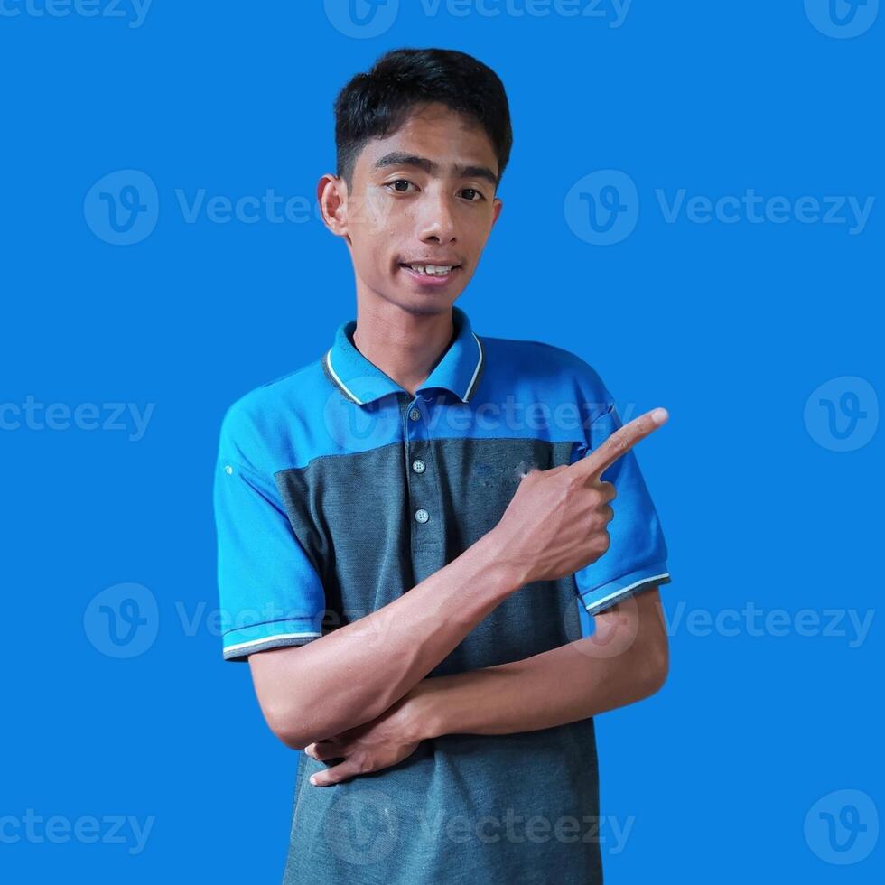 excited asian man wearing white t-shirt pointing to the copy space on the side, isolated white background. photo