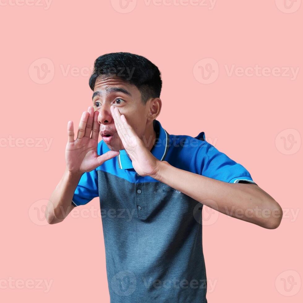 asian man shouting wearing blue t-shirt, isolated blue background. photo