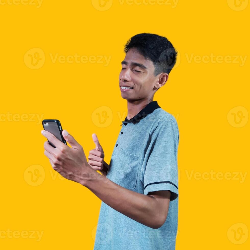 Asian man smiling face with okay gesture holding smart phone, isolated on blue background photo