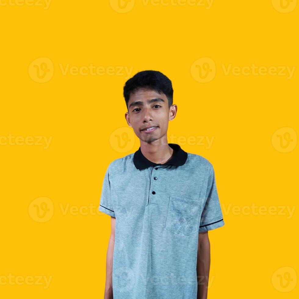 serious young asian man wearing gray t-shirt, isolated yellow background. photo