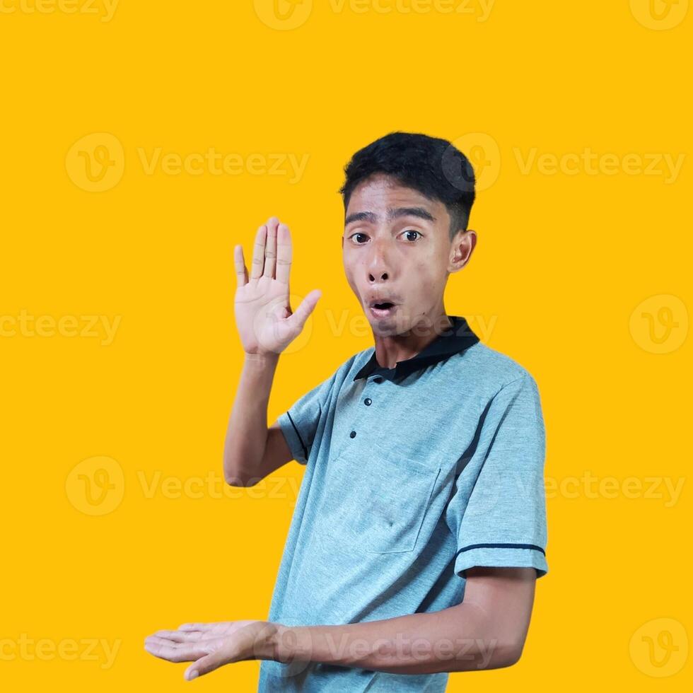 sorprendido asiático hombre con ambos manos formando un fotocopia en el medio área, vistiendo un gris camiseta. foto