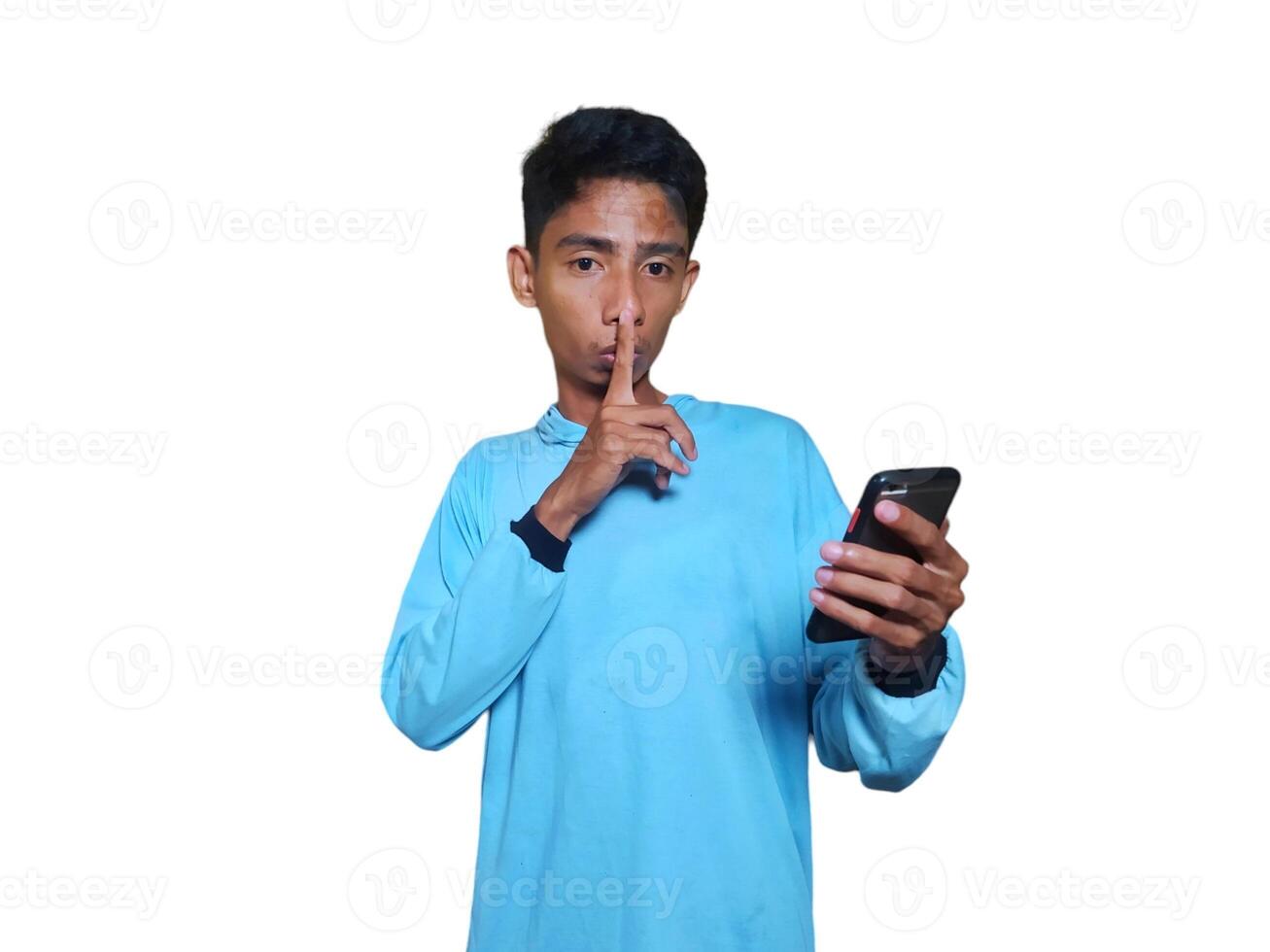 Young Asian man making a secret sign gesture calm sound white background. photo