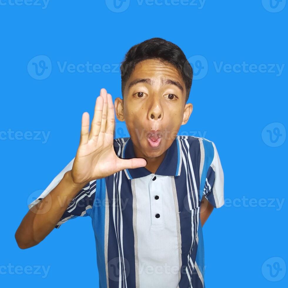young asian man dressed in colorful t-shirt raising arms saying hay meet friends isolated blue background. photo