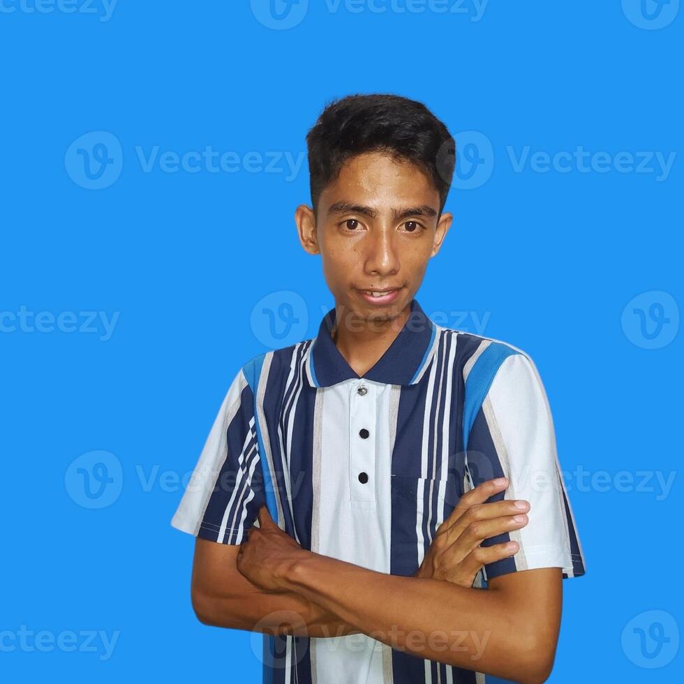 Asian man smiling confidently with folded hands. looking at camera isolated on blue background photo