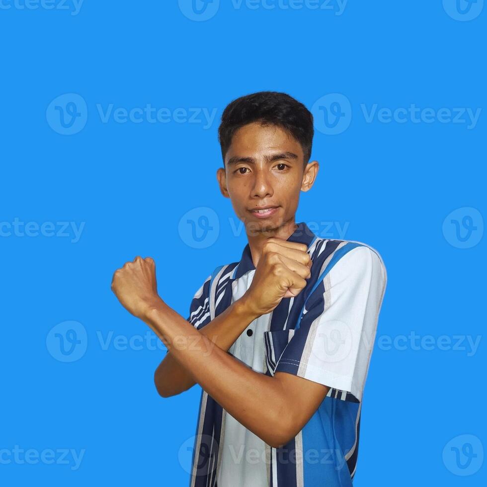 joven asiático masculino cruzado brazos con contento cara aislado azul antecedentes foto