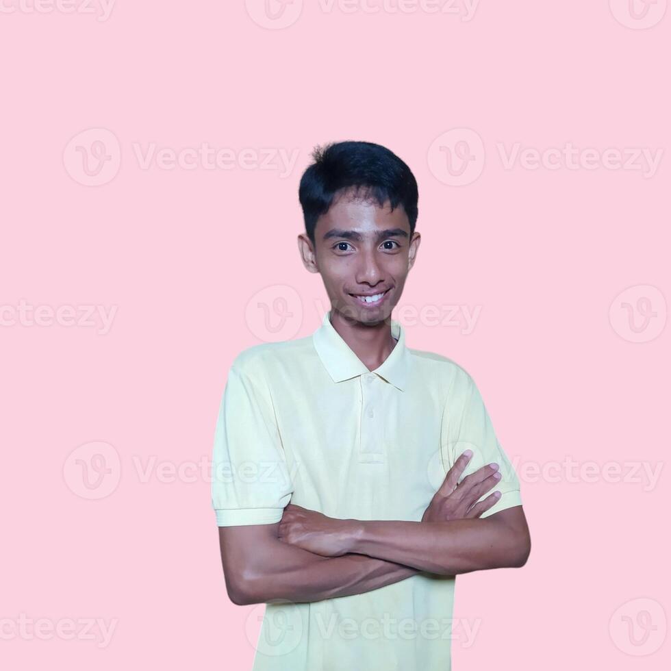 Asian man smiling confidently with folded hands. looking at camera isolated on pink background photo
