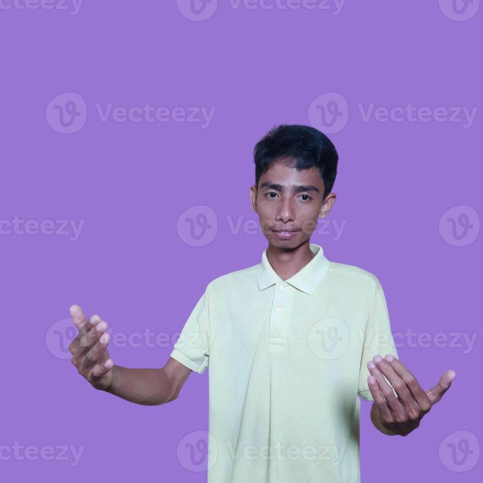 Young Asian man isolated on purple background inviting come with hands, glad you came photo