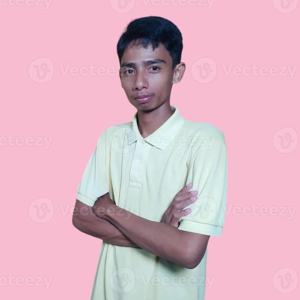 Asian man smiling confidently with folded hands. looking at camera isolated on pink background photo