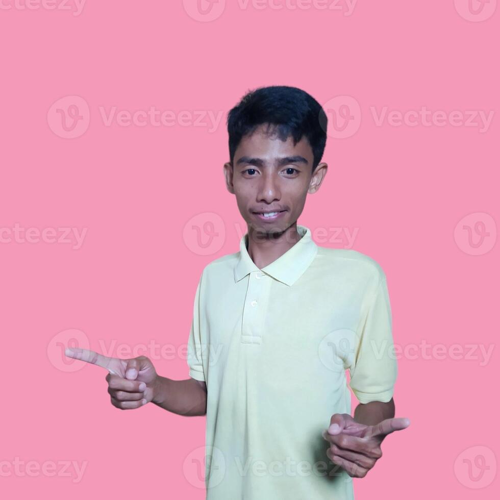 Young asian man surprised looking at smart phone, wearing yellow t-shirt, isolated pink background. photo