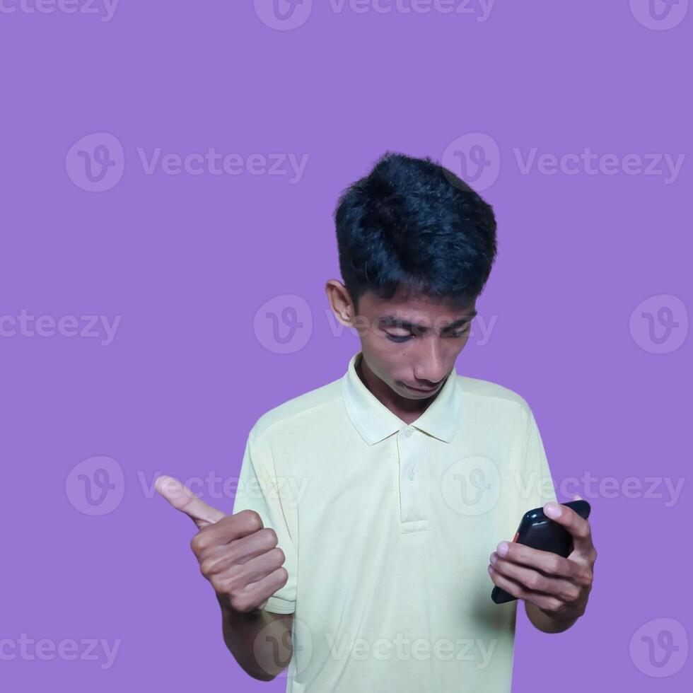 Asian man smiling face with okay gesture while holding smart phone, isolated on purple background photo