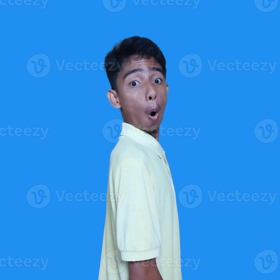 The young Asian man showed a surprised expression. wearing a yellow t-shirt. photo