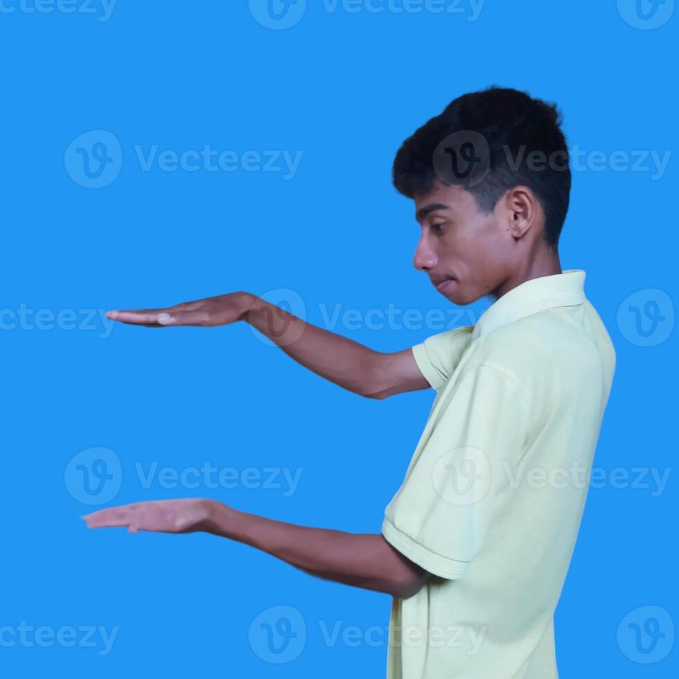 surprised asian man with both hands forming a photocopy in the middle area photo
