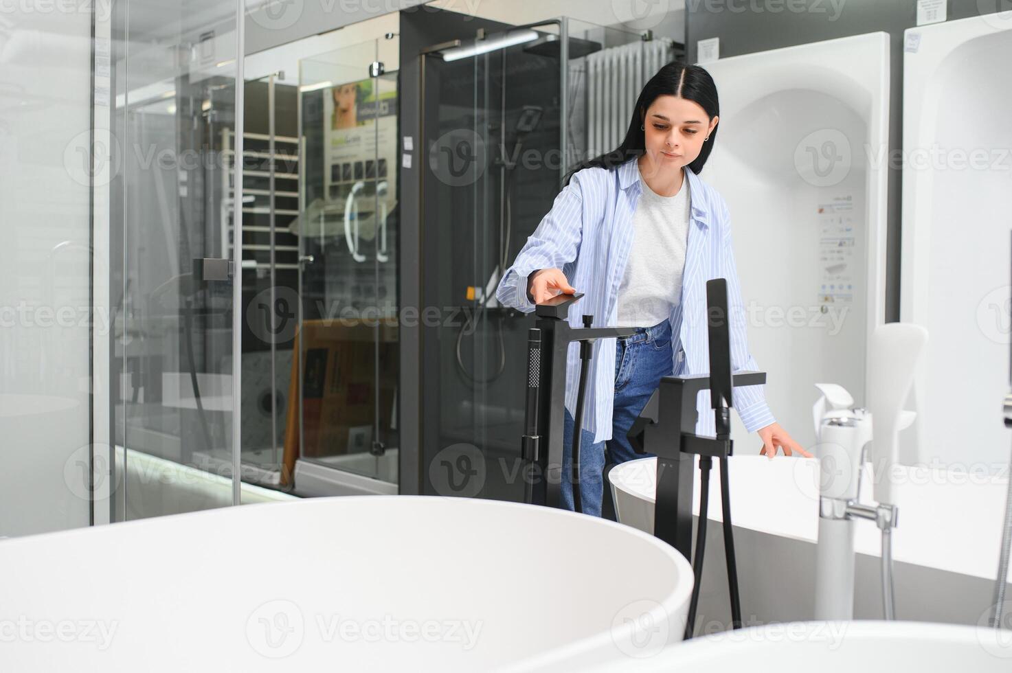 Woman looking for bath at house of ceramics and plumbing materials photo