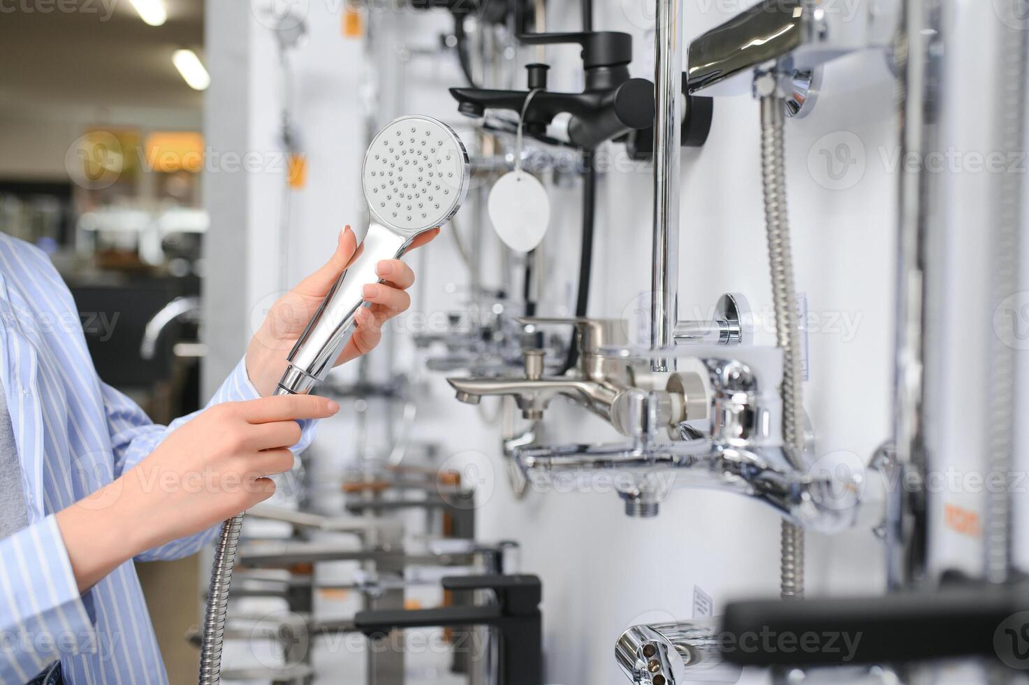 brunette woman looking faucets at plumbing store photo