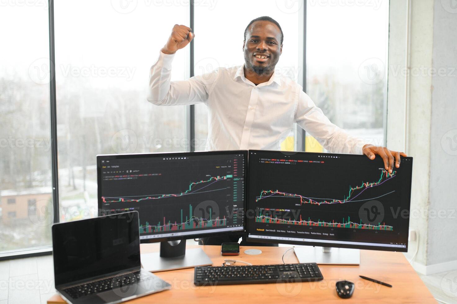 African-American broker works in office using workstation and analysis technology photo