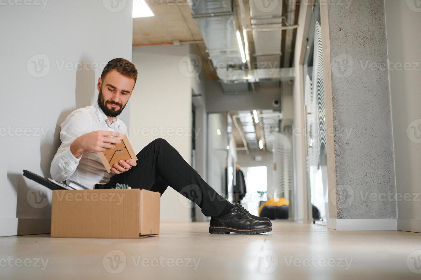 Sad fired businessman sitting outside meeting room after being dismissed photo