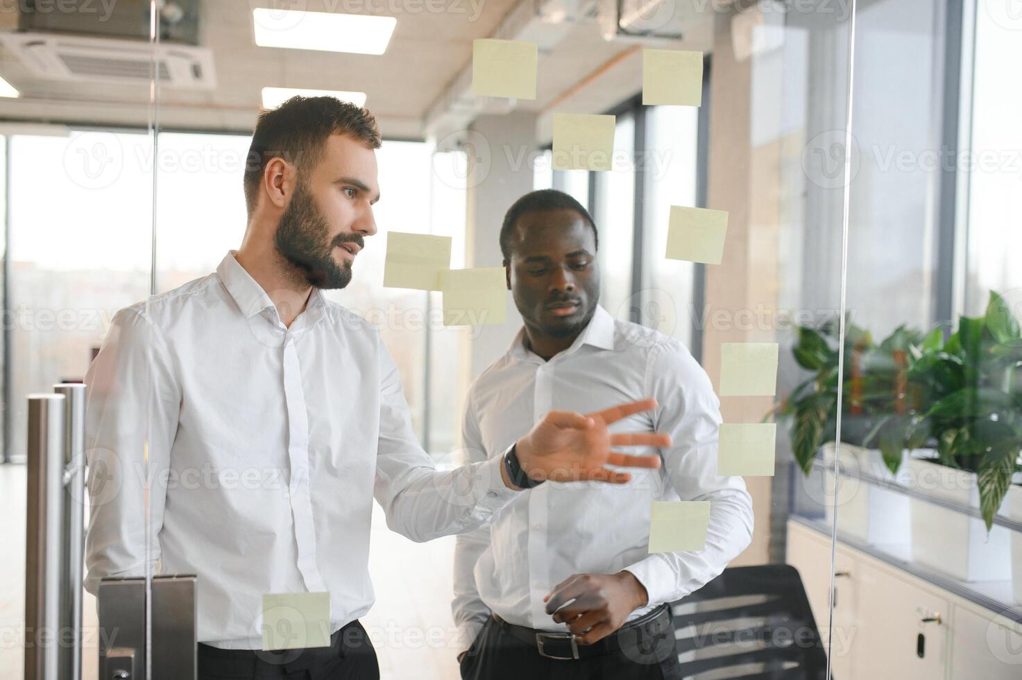 Young businessman manager writing strategy ideas on sticky notes. Business project planning. photo